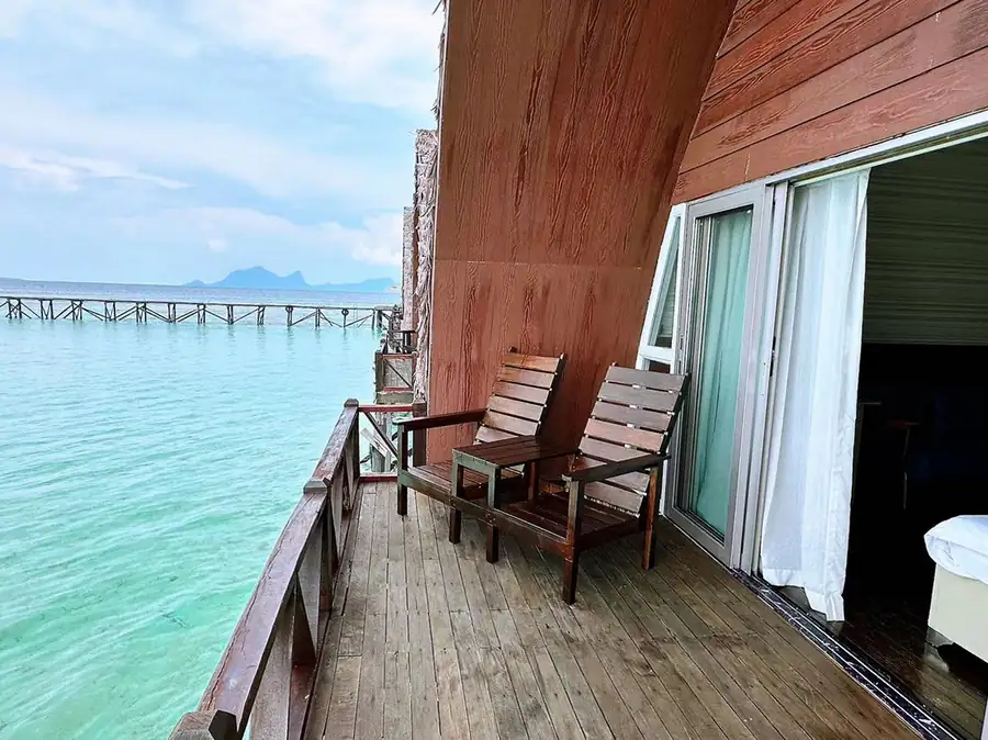 Private oceanview balcony at Crystal Resort featuring wooden seating and uninterrupted views of the Tun Sakaran Marine Park